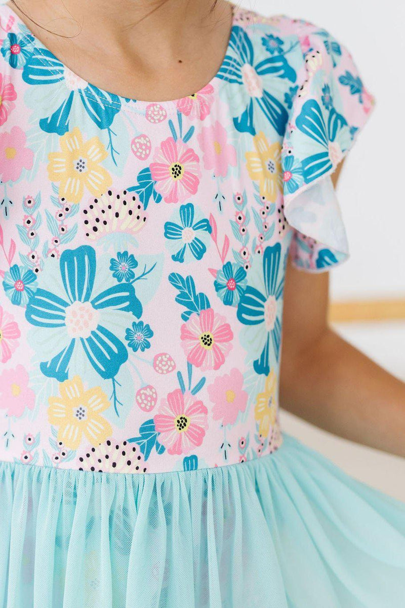 Close-up of the Floral Garden Short Sleeve Twirl Leotard for Girls, highlighting the beautiful floral prints in shades of pink and blue.