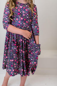 Girl wearing Flower Farm 3/4 Sleeve Pocket Twirl Dress in navy floral print, twirly full skirt with pockets.