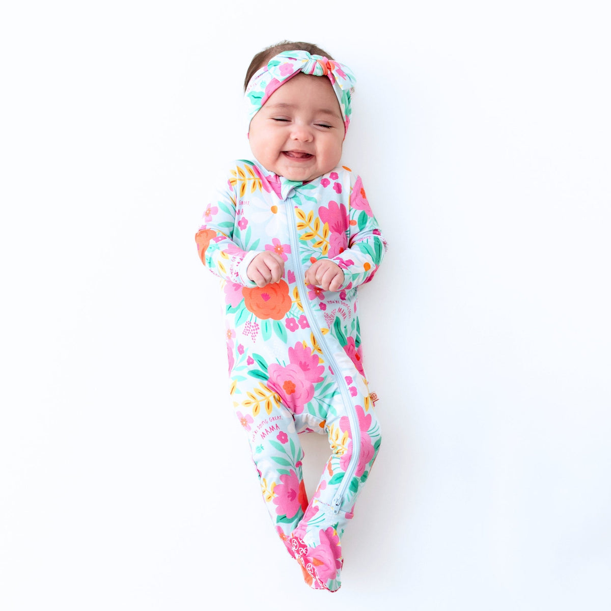The SoftKnot Baby Bow Head Wrap - Babies and Toddlers - Flower Power presented in a flat lay, emphasizing its lightweight and soft texture.