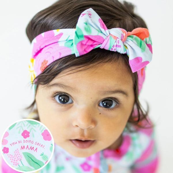 The SoftKnot Baby Bow Head Wrap - Babies and Toddlers - Flower Power. A soft and stretchy baby bow head wrap designed for comfort, featuring a colorful flower pattern.
