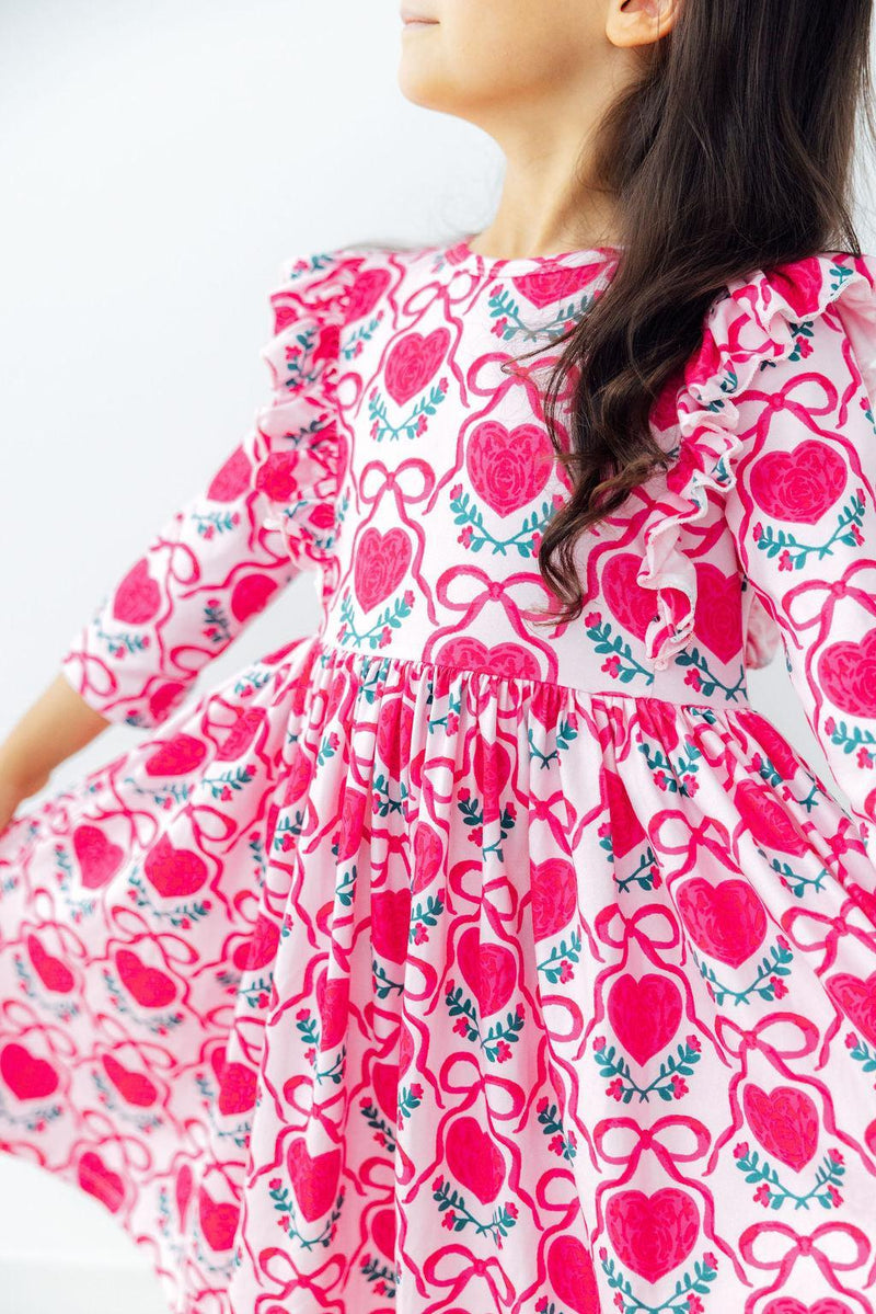 Pink heart print 3/4 sleeve ruffle twirl dress with floral accents, designed for comfortable wear and easy washing.