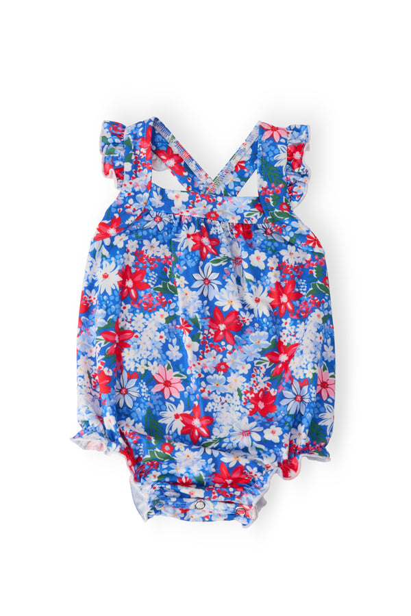 Freedom Flowers Ruffle Cross Back Romper in blue floral print with crisscross back straps, ruffle and snaps.