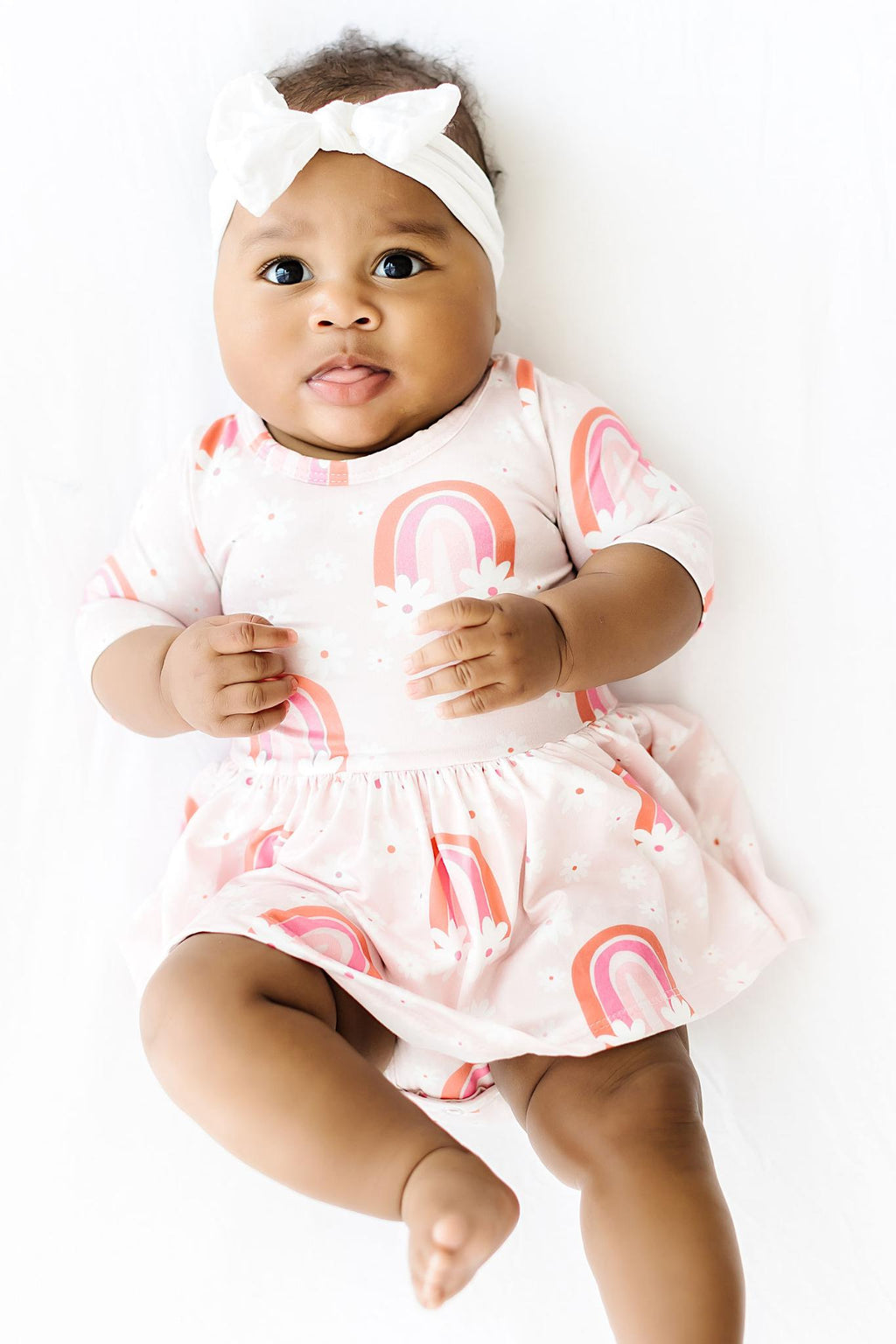 Adorable baby wearing the Fun & Flowers Twirl Bodysuit by Mila & Rose®, featuring a charming rainbow print, brightening up playtime with style and comfort.
