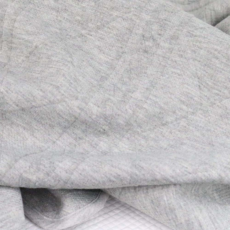 Close-up of the soft fabric of the Gray Knit Blanket by Goosewaddle®, highlighting its texture and gentle touch for delicate skin.