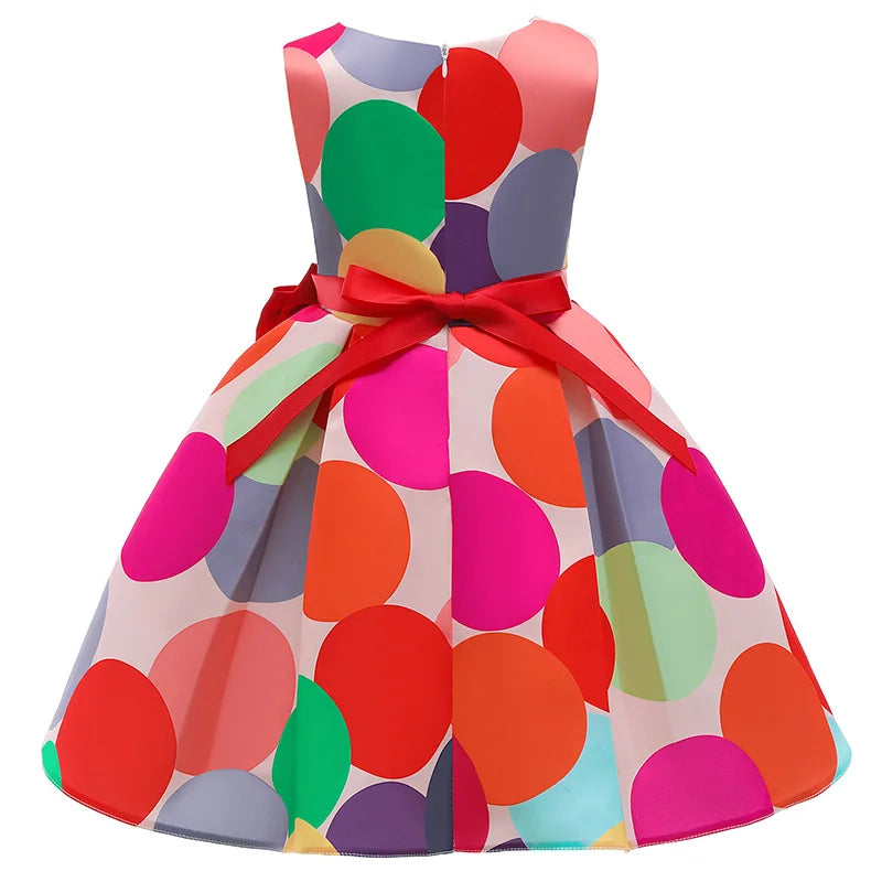 Dotty About Polka Dots dress with vibrant multicolor polka dots and red sash bow at the waist, knee-length.