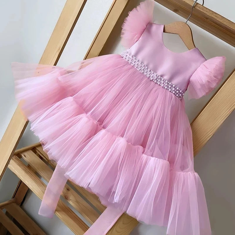 Pretty In Tulle Girls Tulle Party Dress in soft pink, beautifully arranged on a hanger, highlighting the elegant design with puffy sleeves and sequined waist.