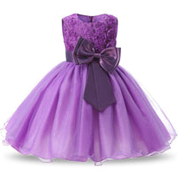 Purple girls occasion dress with floral lace bodice, sparkly tulle skirt, and large satin bow waist.