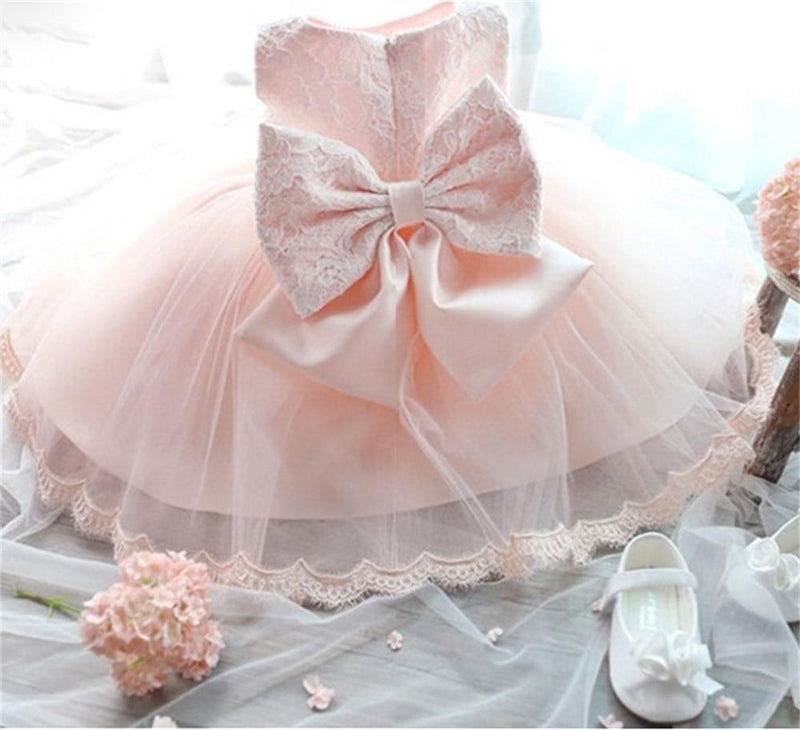 Pink tulle special occasion dress for girls with lace bodice and large satin bow back, featuring breathable cotton lace blend skirt.