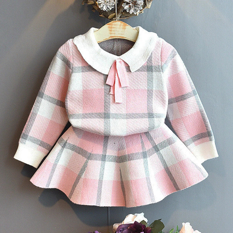 "Sacha Elise" Knitted Girls Plaid Skirt Set in princess pink featuring a round neck and bow tie detail, perfect for ages 2 to 6.