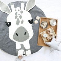 Round rug with a zebra design on a white floor, with a tray of items in the background.