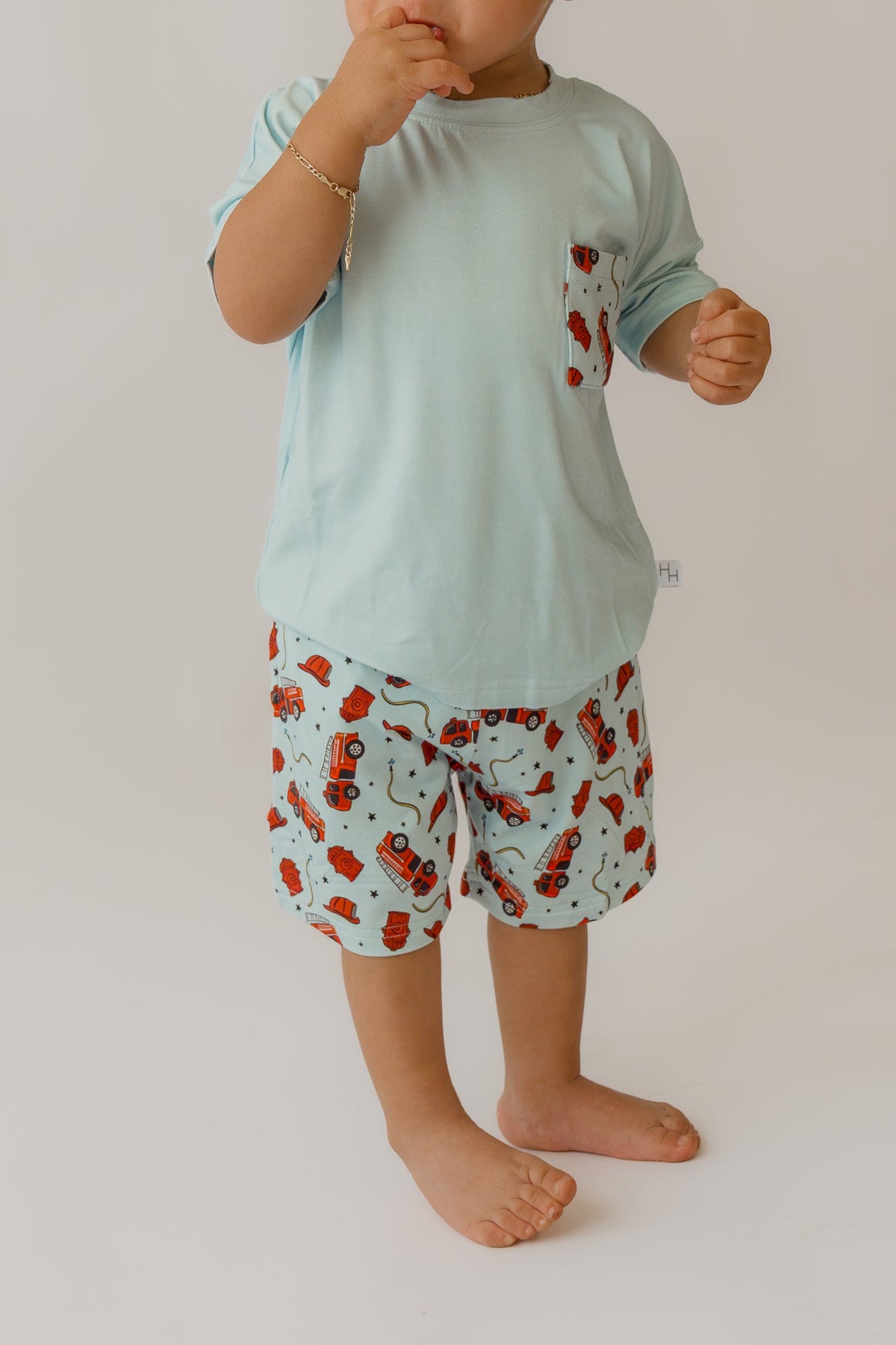 Front detail of light blue t-shirt featuring small chest pocket made from matching fire truck fabric
