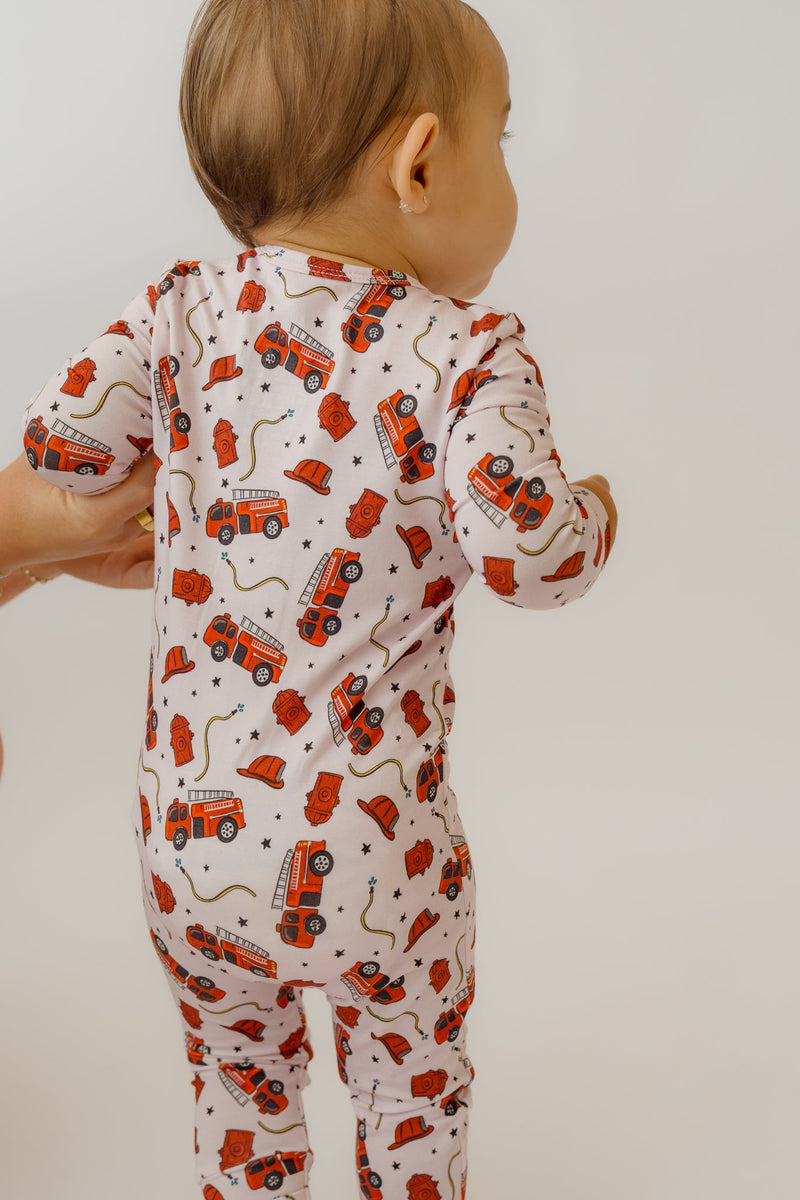 Back view of pink fire engine print baby sleeper stretched over torso and legs