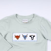 Light blue sweatshirt with embroidered cow design on a white background
