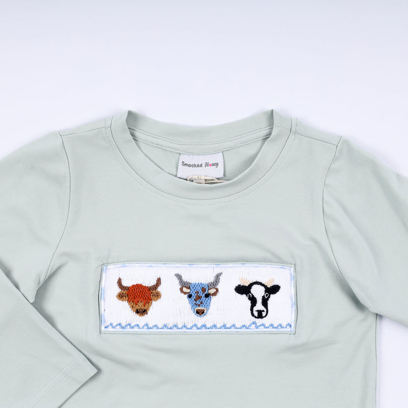 Light blue sweatshirt with embroidered cow design on a white background