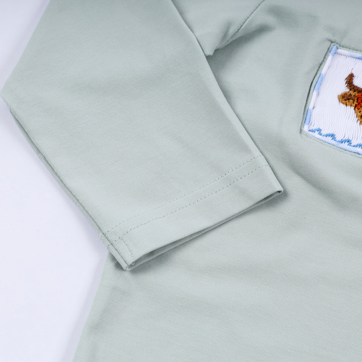 Light green shirt with a patch on the sleeve