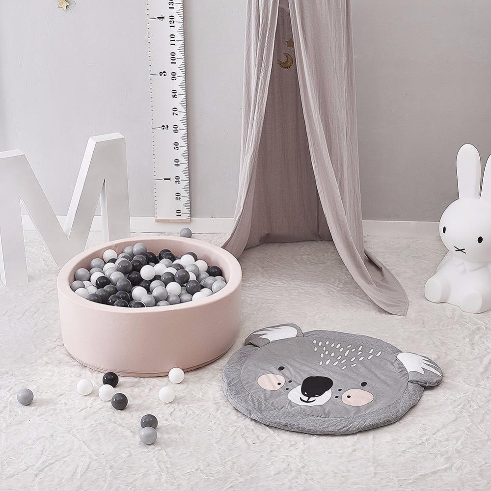 Children's play area with a pink ball pit, koala mat, and decorative elements.