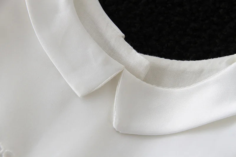 Close-up of a white turn-down collar on a mason dapper formal outfit for boys, featuring a smooth cotton polyester blend.