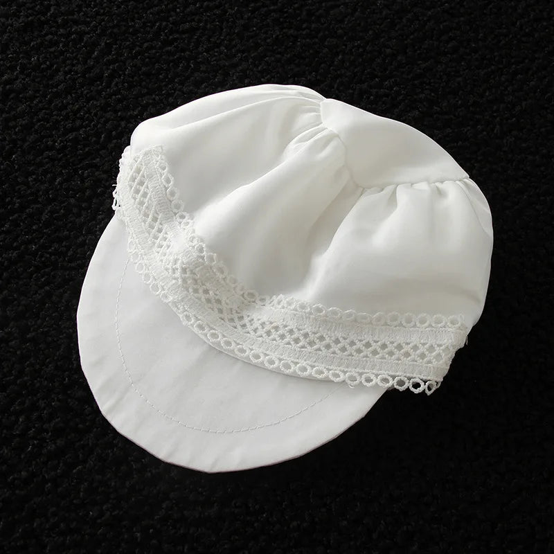 White baby cap with lace trim for formaloccasion outfits. Soft fabric newsboy hat for newborns and toddlers.