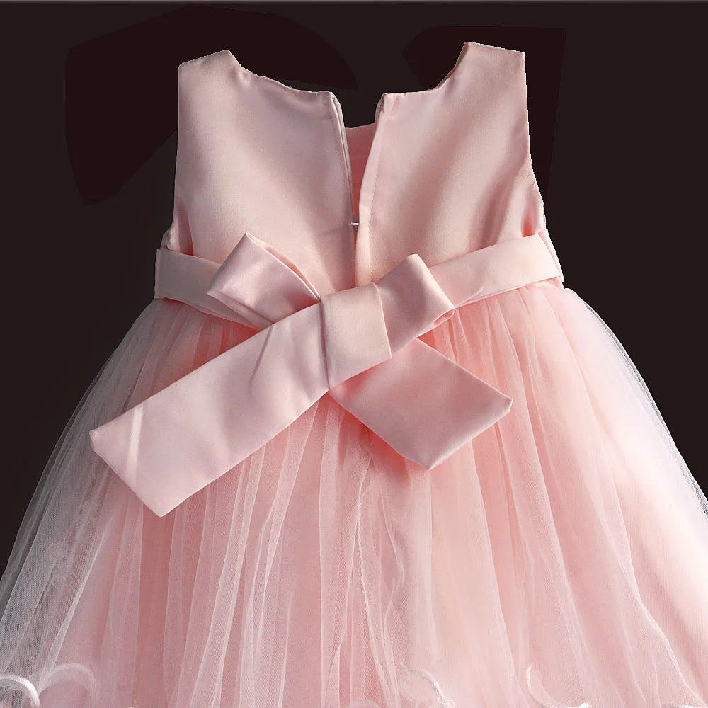 Pink newborn baby party dress with large satin bow at waist, sleeveless neckline, knee-length tulle skirt, back zip.