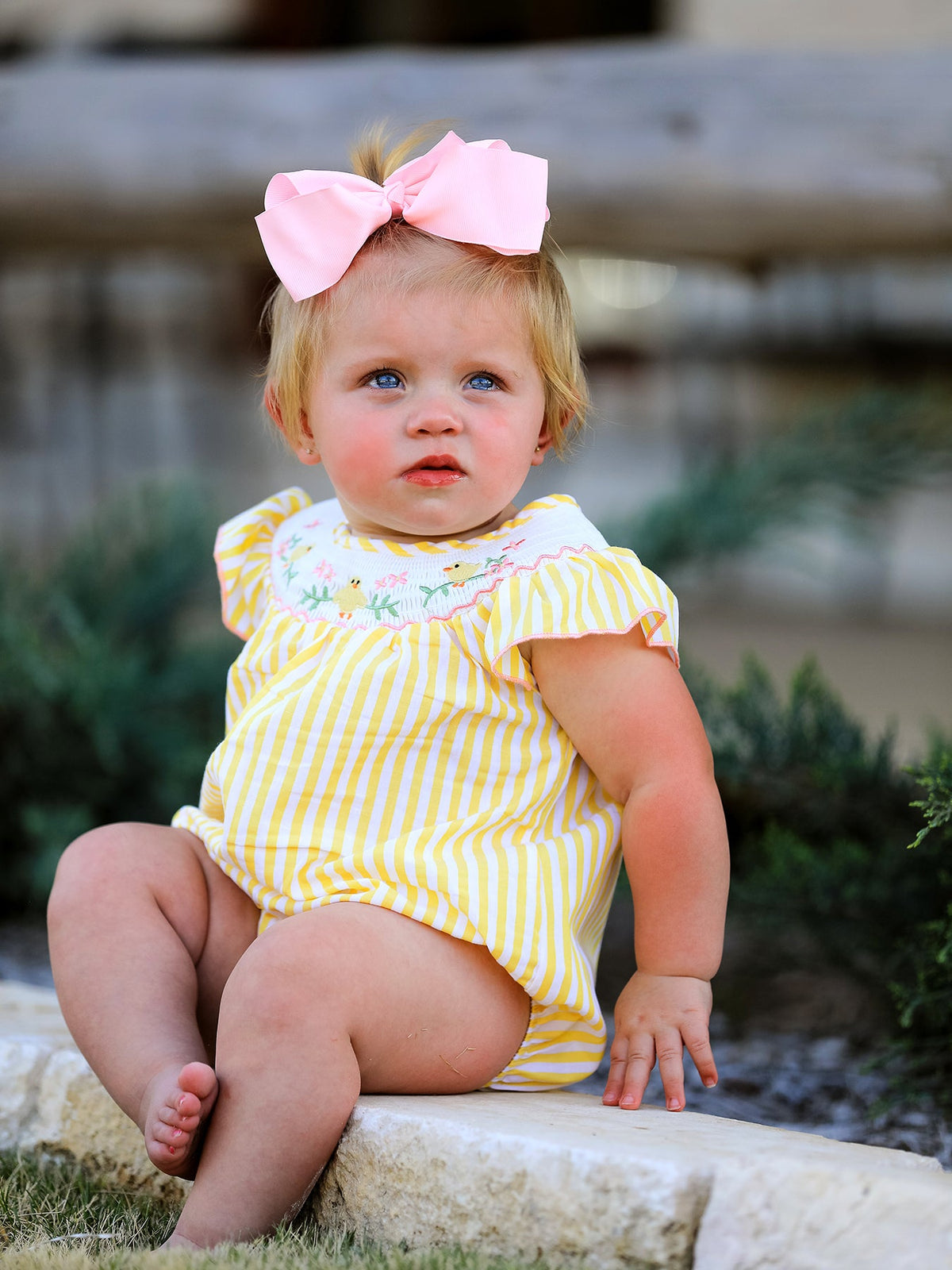 Full view of a girl wearing the Spring/Summer Chick Floral Embroidery Smocking Girls Romper outdoors, perfect for summer play.
