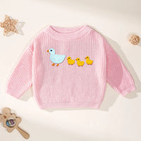 Soft pink long sleeve sweater with blue goose and yellow chicks embroidery next to wooden toys