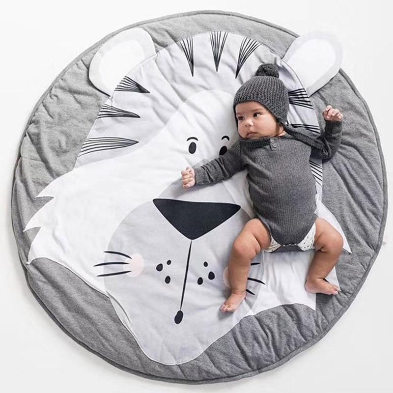 Baby lying on a round, gray and white rug with a cat design, wearing a matching outfit.