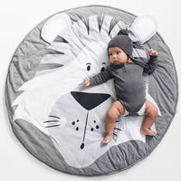 Baby lying on a round, gray and white rug with a cat design, wearing a matching outfit.