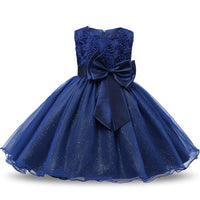 Navy blue girls' special occasion dress with floral lace bodice, big satin bow, and glitter tulle skirt.