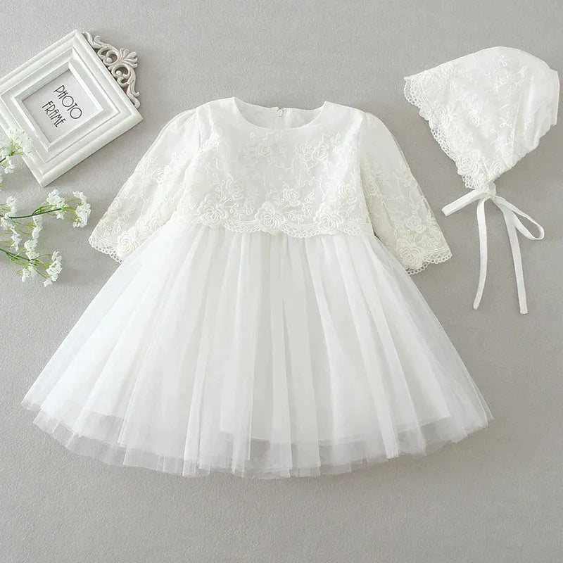 White lace baby dress with matching bonnet on a gray background