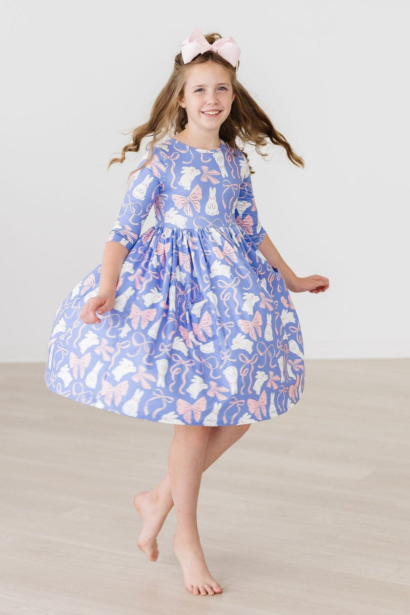 Girl twirling in the Hop, Skip & Twirl 3/4 Sleeve Pocket Twirl Dress, demonstrating the dress's playful movement and design, ideal for active kids.