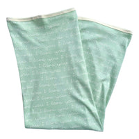 GOTS certified organic cotton baby blanket in desert green with white "i love you" script pattern and cream binding.