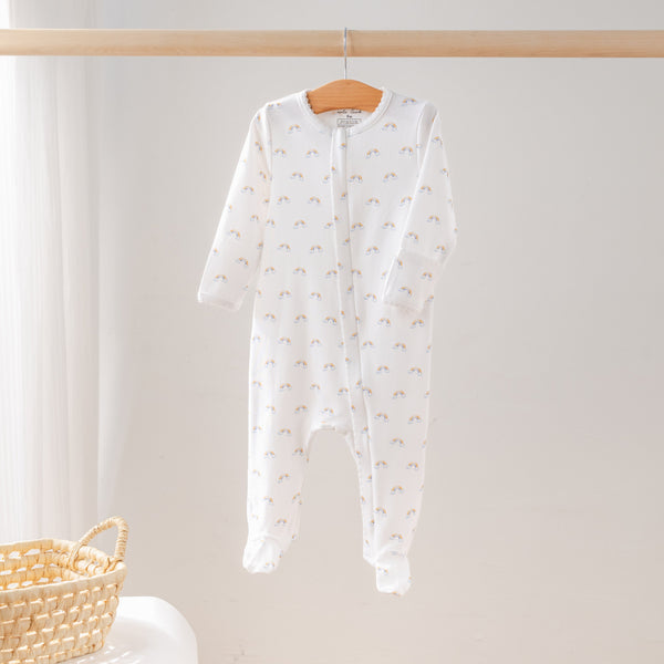White baby onesie with small patterns on a wooden hanger against a light background
