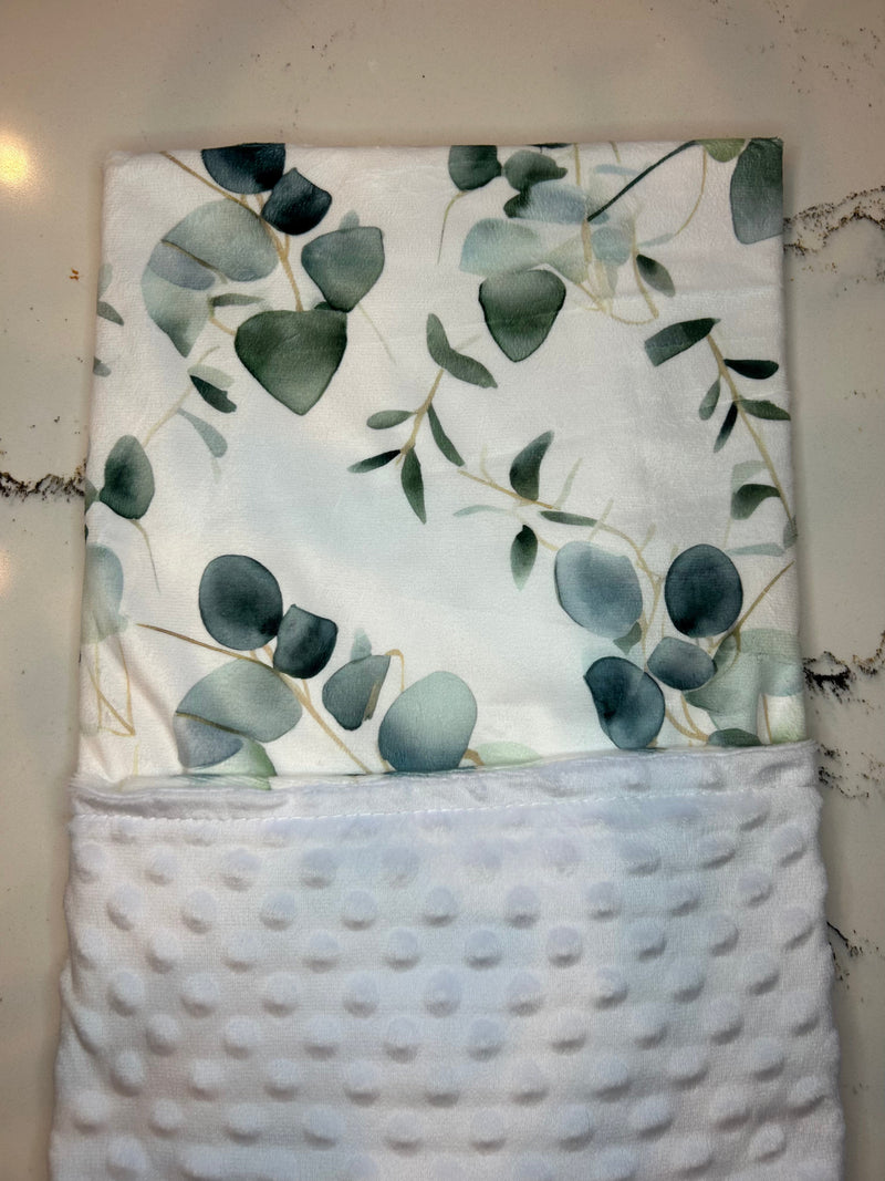 Close-up view of the Eucalyptus Embrace Minky Blanket's hypoallergenic fabric, emphasizing its lightweight durability and artistic flair for the cozy connoisseur.