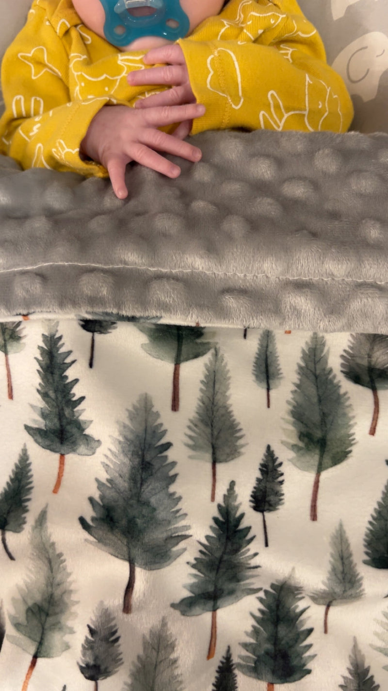 The Woodland Whispers Minky Blanket artfully draped on a chair, adding a touch of cozy elegance to any home decor.