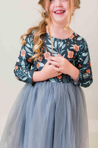 Girl wearing a floral long sleeve tutu dress in "Into the Night" print with a grey tulle skirt. Perfect for dressing up or play.