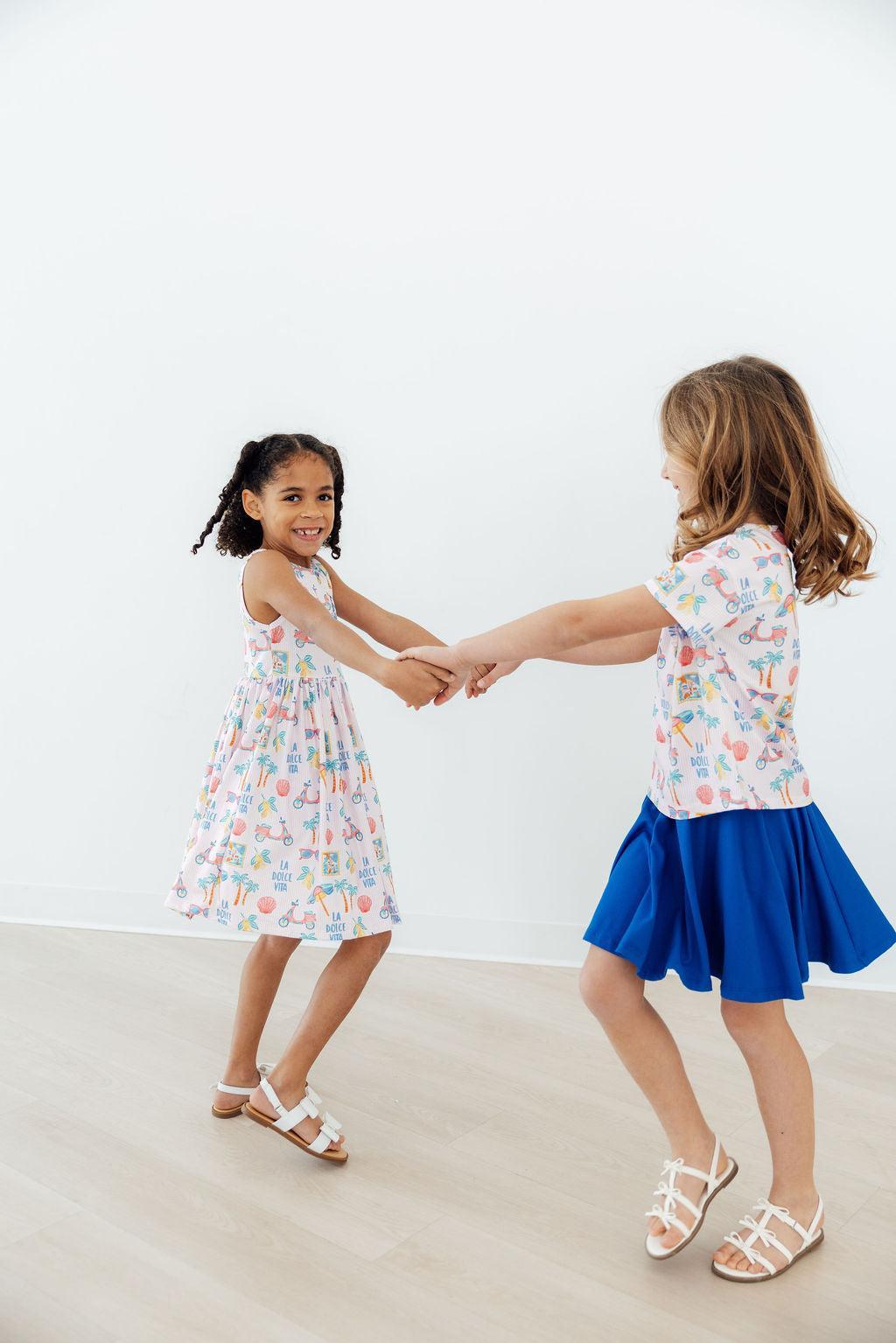 Child twirling in the Sweet La Dolce Vita Summer Tank Twirl Dress for Girls, capturing the fun movement of the dress.