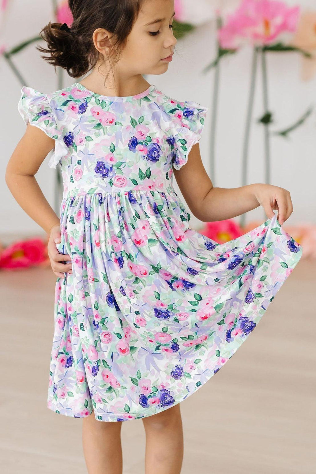Adorable child in Lavender Love Flutter Sleeve Twirl Dress, showcasing flutter sleeves and a twirly skirt, perfect for playful spins. Glamour meets comfort for little fashionistas!