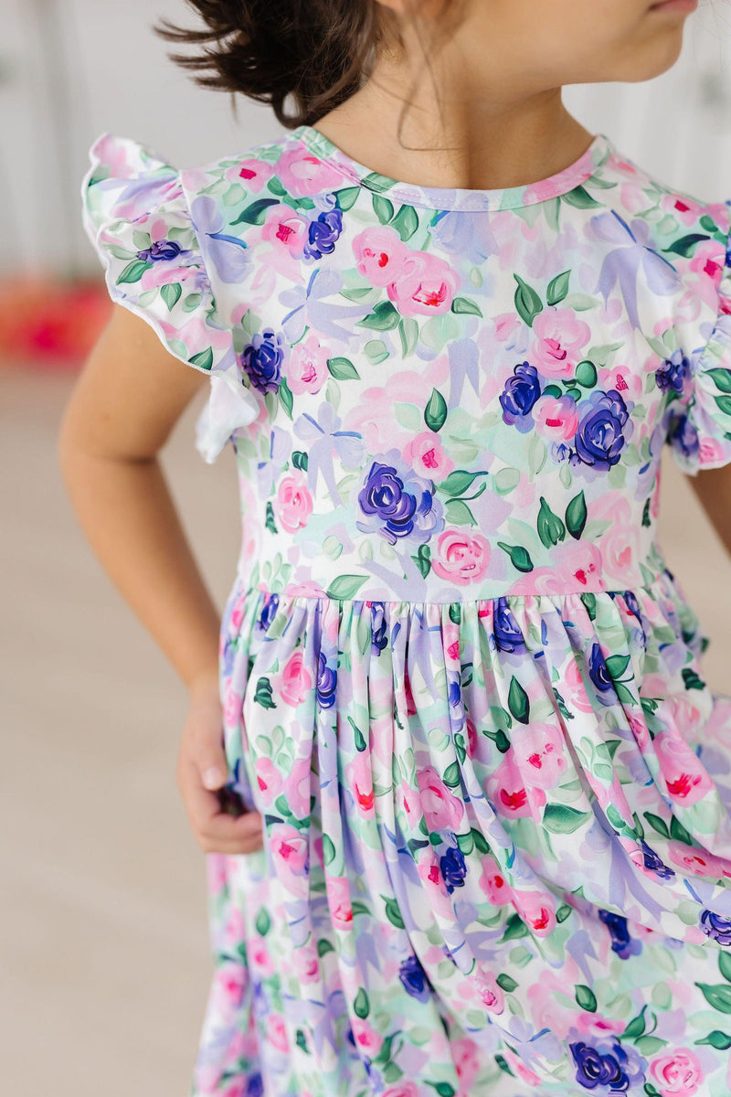 Close-up of Lavender Love Flutter Sleeve Twirl Dress, highlighting the vibrant floral pattern and flutter sleeves, a delightful choice for little ones who love style and twirl.