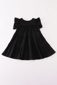 A black tiered baby dress with ruffled short sleeves, laid flat against a plain white background.