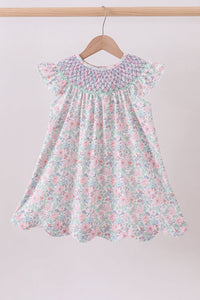 Floral dress on a hanger against a plain background