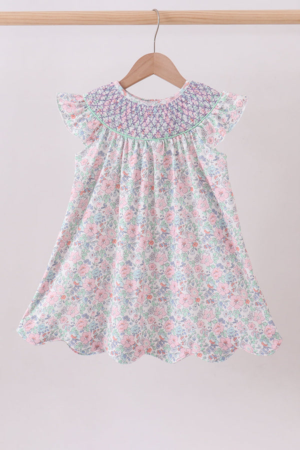 Floral dress on a hanger against a plain background