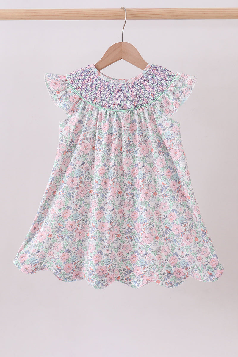 Floral dress on a hanger against a plain background