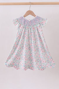 Floral dress hanging on a wooden hanger against a light background