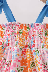 Colorful floral dress with blue straps on a white background