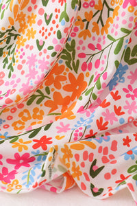 Colorful floral fabric with pink, orange, green, and blue flowers on a white background