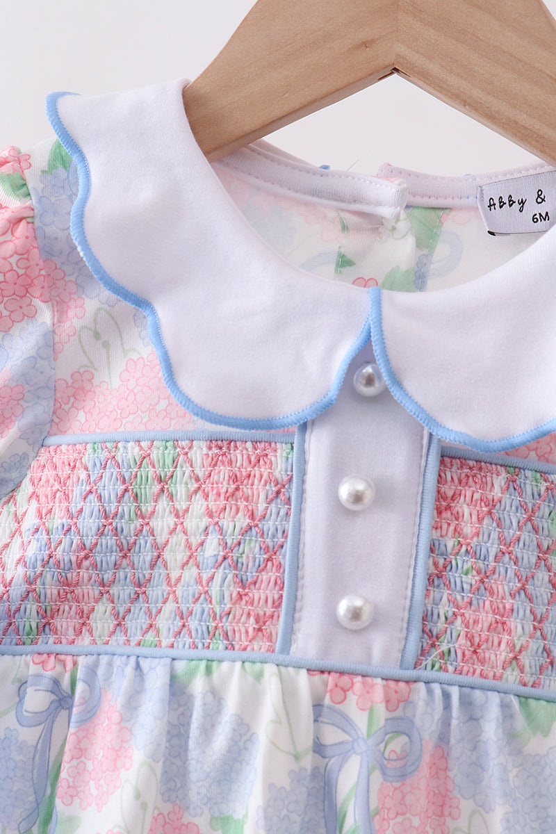 Children's dress with smocked details on a hanger, brand 'abby & otto' visible.