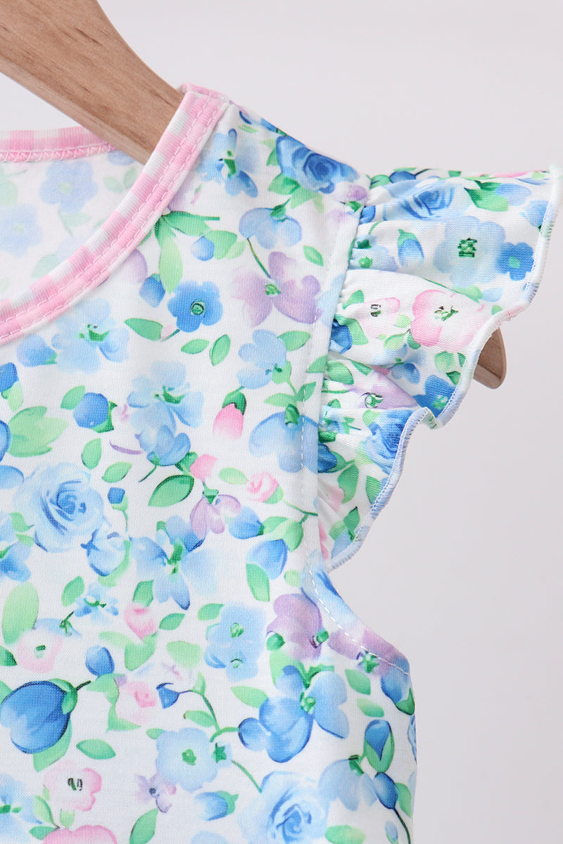 Blue floral dress with ruffled sleeve and pink neck trim features soft blue, purple, and green watercolor flowers on white fabric.