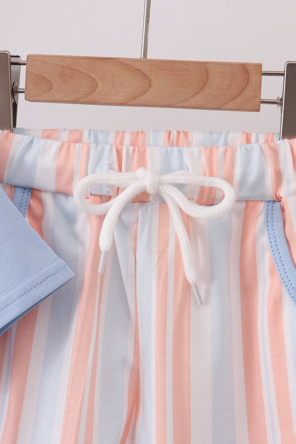 Pastel pink, blue, and white striped pants waistband with white drawstring bow on wooden hanger, coastal-inspired set detail.