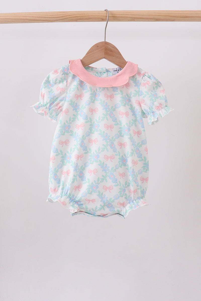 Baby bubble romper with pink floral bow print, pink Peter Pan collar, and short puff sleeves.