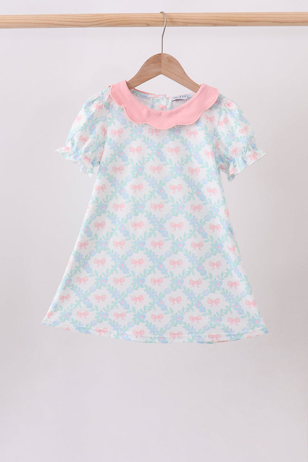 Pink Floral Bow Print Dress on a wooden hanger, pink collar, pastel blue bow pattern, short puff sleeves.